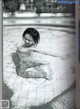 A black and white photo of a woman in a swimming pool.