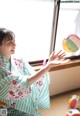 A woman in a kimono playing with a ball.