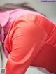 A woman in a pink shirt is bending over.