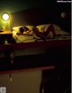 A woman laying on a bed in a dark room.