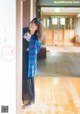 A woman standing in a room with a wooden floor.