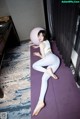 A woman sitting on a yoga mat with a pink ball.