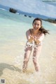 A woman in a bikini playing in the water at the beach.