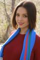 A woman wearing a red shirt and a blue scarf.